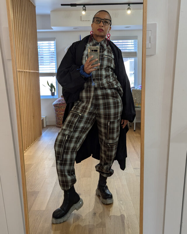 Anita wears an outfit consisting of top and pants from by GU x Undercover, jacket is Monitaly, boots are Rick Owens and earrings by Warren Steve Scott. 